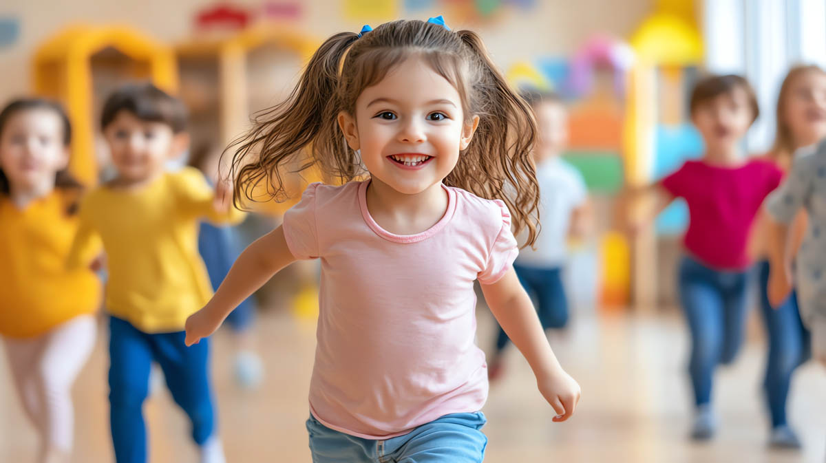 A little girl with a big smile runs towards the camera, her long hair flowing behind her.